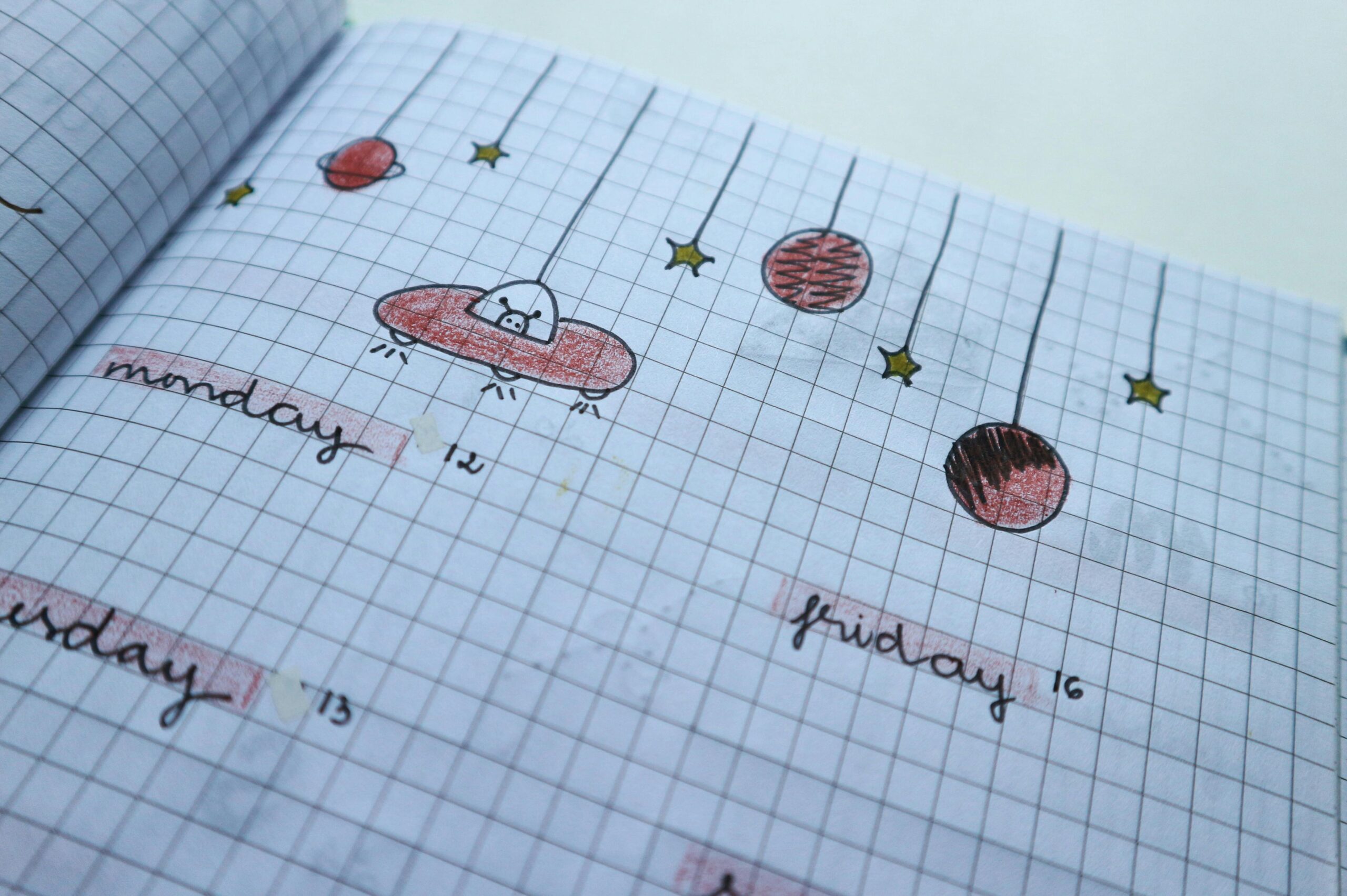 Close-up of a hand-drawn weekly planner page with cute, creative designs and grid layout.
